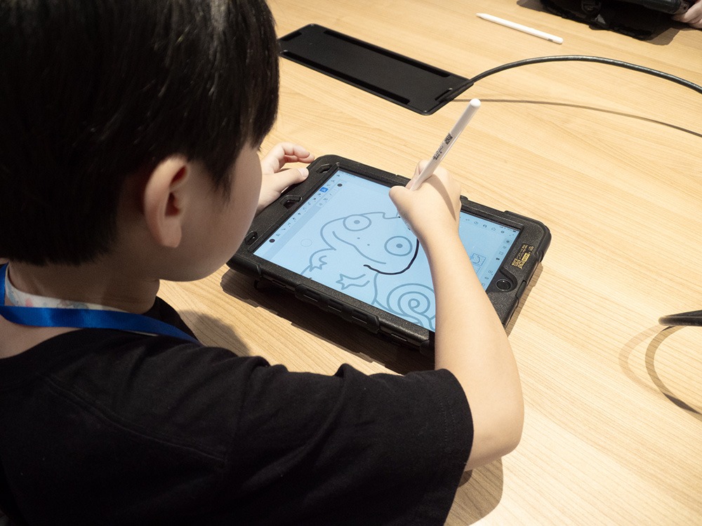 写真:子どもがタブレットで絵を描いているようす